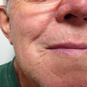 A close up of an older man 's face with wrinkles.